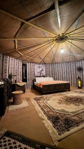 a bedroom with a bed in a room with rugs at SAFARI-Glamping in Badīyah