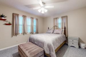 - une chambre avec un lit, un ventilateur de plafond et des fenêtres dans l'établissement Lakeside Eden, à Pine Crest