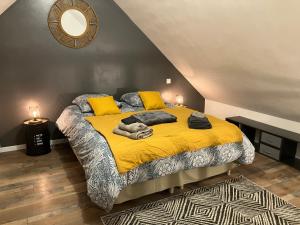 a bedroom with a bed with yellow sheets and yellow pillows at Loft Le Petit Solognot in Mont-près-Chambord