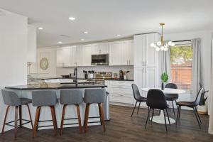 a kitchen with white cabinets and a table and chairs at Modern Comforts & Classic Charm w Pool 5BD in Saginaw