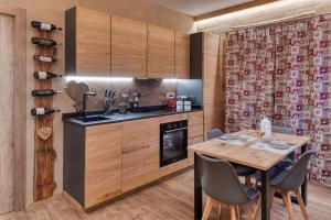 a kitchen with a wooden table and a dining room at La Certosa in Chiusa di Pesio +3 photos