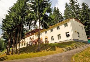 a large white building with trees in front of it at Horský Hotel Magura in Chvojnica