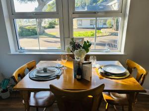 a dining room table with chairs and a large window at The South Promenade apartment in Newcastle