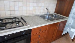 una cocina con fregadero y estufa en Villaloddo 3 Marina di Tertenia cap 08047 dietro Ristorante La Grotta, en Tertenìa 49 fotos más