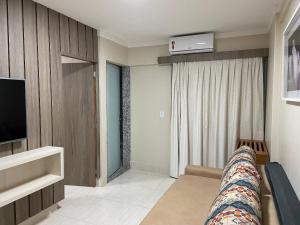 a living room with a couch and a television at Hotel Piazza diRoma com acesso ao Acqua Park e Splash in Caldas Novas