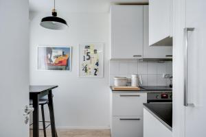 a kitchen with white cabinets and a black counter top at Rent a box Turku City Center in Turku
