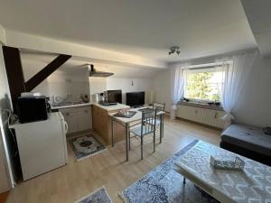 a kitchen and living room with a table and a refrigerator at Ferienwohnung im Deister in Springe