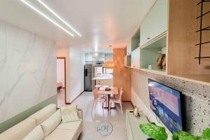 a living room with a white couch and a table at Flat Patacho - Rota Ecológica dos Milagres in Pôrto de Pedras
