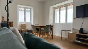 a living room with a couch and a table with chairs at Casa Cidalisa in Povoação