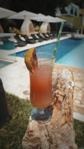 a drink sitting on a log next to a pool at Dharma Hotel Boutique Spa in San Jerónimo