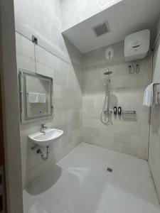 a white bathroom with a sink and a mirror at Pandawa House Bali in Uluwatu