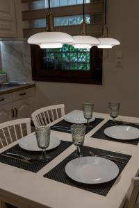 a kitchen with a table with plates and glasses on it at "Meteora Magic" apartments in Kalabaka