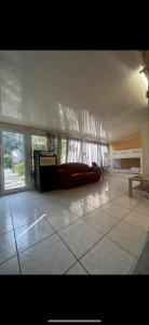 a living room with a red couch and windows at Agréable Dortoir en bord de jardin Lit 2 in Castres