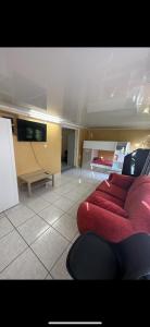 a living room with a red couch in a room at Agréable Dortoir en bord de jardin Lit 2 in Castres