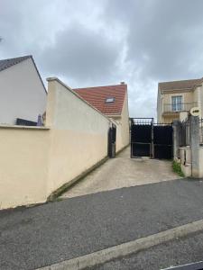 a fence with a gate in front of a house at Appartement khezia in Champigny-sur-Marne