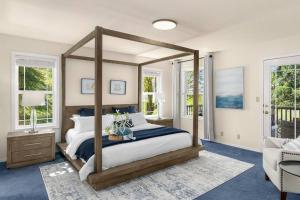a bedroom with a canopy bed in a room with windows at Puget Sound Sunset - Whidbey Ocean Front home with C in Oak Harbor