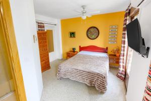 a bedroom with a bed and a flat screen tv at AstArte Guesthouse in Castillo de Locubín