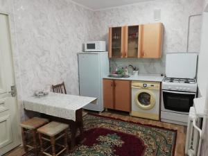 a small kitchen with a table and a microwave at 20 дом у моря in Aktau
