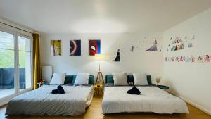 ブシー・サン ・ジョルジュにあるMickey Mouse - Gare - Centre - Lac - Parking - Wifiの壁に絵が飾られた部屋にベッドが2つある