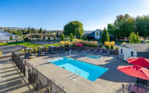 an outdoor swimming pool with umbrellas and umbrellas at The Lodge Lake Chelan in Manson