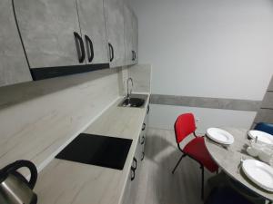 a kitchen with a table and a red chair at HotelRoom 27 in Uzhhorod