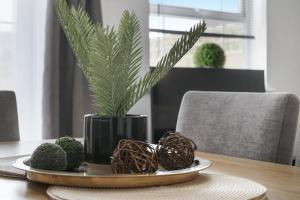 un piatto con una pianta in un vaso nero su un tavolo di Aylesbury 3BR Home, Sleeps 5,Ideal for Families & Contractors Homely Stay a Buckinghamshire