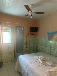 a bedroom with a bed and a ceiling fan at Pousada da Lurdinha in Lençóis