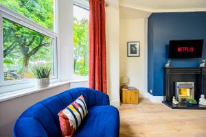 a living room with a blue chair and a fireplace at Stunning House Sleeps 7 - Parking in Buxton