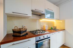 a kitchen with white cabinets and a stove top oven at Flexible SelfCheckIns 102 - Zagreb - Parking - WIFI - Loggia in Zagreb