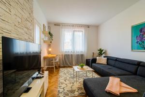 a living room with a couch and a large flat screen tv at Flexible SelfCheckIns 102 - Zagreb - Parking - WIFI - Loggia in Zagreb