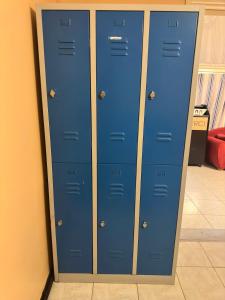 three blue lockers in a room next to a wall at Agréable Dortoir en bord de jardin Lit 3 in Castres
