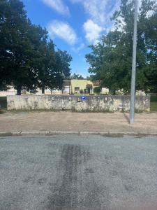 an empty parking lot next to a stone wall at Agréable Dortoir en bord de jardin Lit 3 in Castres +1 photo