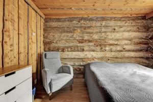 a bedroom with a bed and a chair at Bliss Adventure Lodge in Pyhätunturi