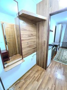a bathroom with a mirror and a wooden wall at Астана аэропорт студия in Prigorodnyy