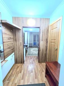 a room with a hallway with wooden floors and a door at Астана аэропорт студия in Prigorodnyy