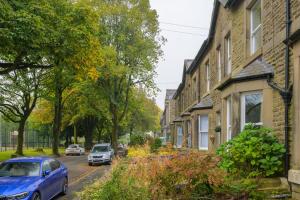 a blue car parked on a street next to houses at Stunning House Sleeps 7 - Parking in Buxton