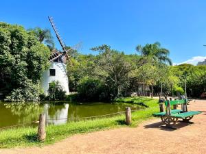 a green bench next to a pond with a windmill at Quality Porto Alegre in Porto Alegre
