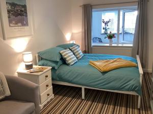 a bedroom with a bed with pillows and a window at Bluebirds villa in Padstow +29 photos