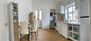 a kitchen with white cabinets and a table and chairs at Casa Cidalisa in Povoação