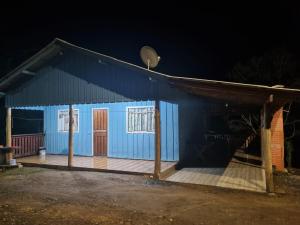 a blue building with a porch at night at Rancho do Pijuca real in Ortigueira