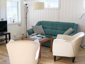 a living room with a green couch and two chairs at Amazing holiday home in the nature-By Traum in Laholm