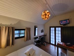 a bedroom with a bed and a chandelier at Pousada Vila Santa Barbara in São Francisco Xavier