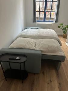 a bed in a room with a table next to it at L'Escapade Médiévale Appartement neuf in Josselin