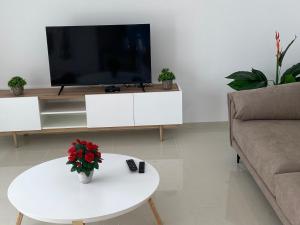 a living room with a tv and a table with flowers at Vera Apartment mit Garten in Ciudad Quesada