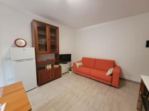 a living room with a red couch and a refrigerator at Casa Rosi - appartamento in Monzuno