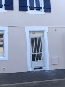 a white building with a door and a window at appartement cosi proche de tout in Biarritz +3 photos