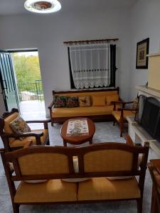 a living room with couches and a tv at Dimitris House in Pramanta