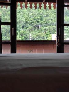 a window in a room with a view of trees at Pousada Casa do Oscar in Governador Celso Ramos