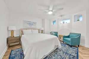 a bedroom with a white bed and a blue chair at The Washington Downtown Boutique Hotel in Sandusky