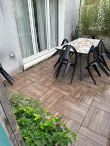 モンテヴランにあるDuplex Le G - proche Disneylandのデッキにテーブルと椅子が置かれたパティオ